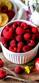 Fresh raspberries with apples and flowers on a rustic table background.