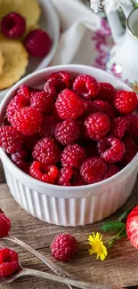 A bowl of fresh red raspberries on a rustic table.