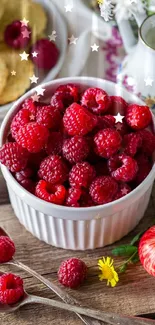 Fresh raspberries in a white bowl with rustic decor and flowers.