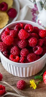 A bowl filled with fresh red raspberries, perfect for a vibrant phone wallpaper.