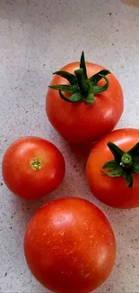 Vibrant red tomatoes on a light surface.