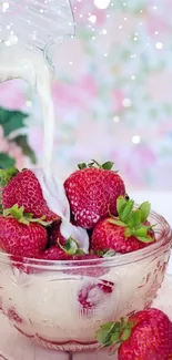 Strawberries in a pink bowl with cream poured over them.