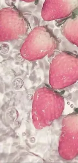 Pink strawberries floating in water with bubbles creating a refreshing aesthetic.