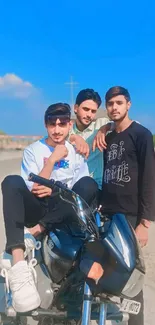 Three friends sitting on a motorcycle under a bright blue sky.