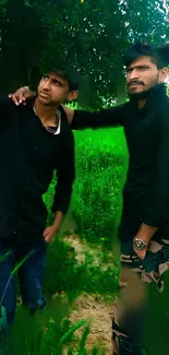 Two friends in nature with lush green background, wearing casual attire.