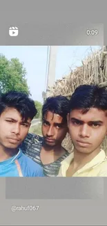 Three friends pose outdoors with greenery background.