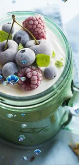 Frosted berries on yogurt in a green mug with a mint backdrop.