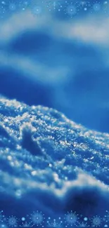 Frosty blue snow close-up wallpaper with shimmering snowflakes.