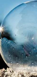 Close-up of a frosted bubble on icy surface with sky blue background.