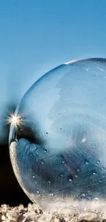 A frosty bubble reflecting light against a bright blue sky.