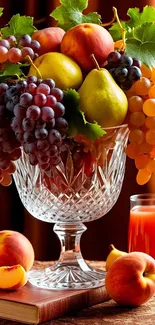 A colorful arrangement of fruits in a crystal glass with a juice glass.
