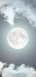 Full moon surrounded by soft clouds in a light blue sky.