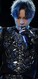 Man wearing a futuristic black outfit on stage.