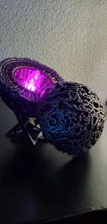 Futuristic sculpture glowing with purple light on a textured surface.