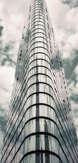 Futuristic skyscraper reaching into cloudy sky.