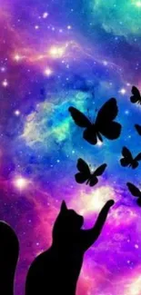 Silhouette of a cat reaching for butterflies against a vivid galaxy background.