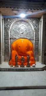 Ganesh temple with orange statue and intricate marble details.