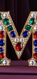 Gem-encrusted letter M with vibrant jewels on display