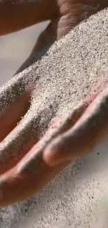 Serene image of sand falling through a hand.