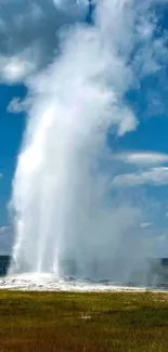 Geyser erupting under a vibrant blue sky.