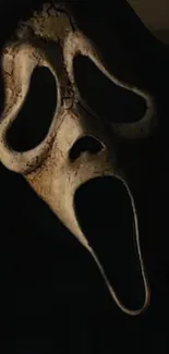 Dark ghost face mask wallpaper with eerie black background.