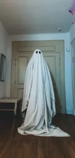 A ghostly figure draped in a white sheet stands eerily in a dim, beige-toned room.