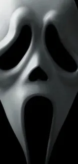 Ghostly white mask on dark background wallpaper.