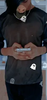 Person holding phone with ghost decals in dark-themed wallpaper.