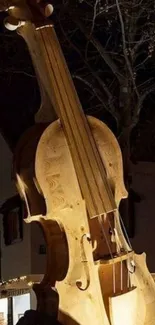 Wooden violin sculpture at night with a dramatic background.