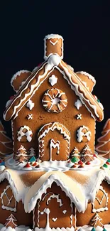 Gingerbread house with icing decorations and holiday trees on a dark background.