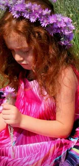 Girl in pink dress with flowers in a meadow background.