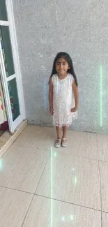 Young girl in white dress by a colorful doorway indoors.