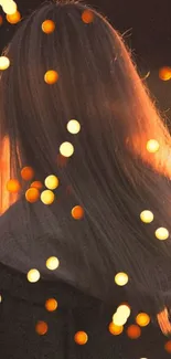 Silhouette of a girl with glowing bokeh lights in warm orange tones.