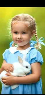 Little girl in blue dress holding a bunny.