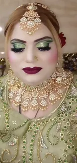 Bridal portrait showcasing intricate jewelry and glamorous makeup on a green background.