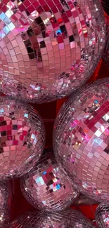 Multiple pink disco balls with dazzling reflections.