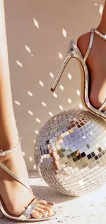 High heels with disco ball reflecting light on beige background.