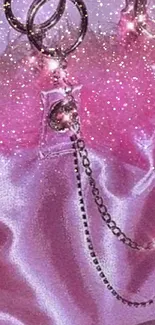 Luxurious pink satin bag with sparkling chains against a soft background.