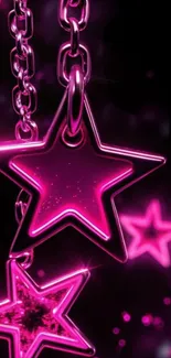Pink star charms on chains with a dark background.