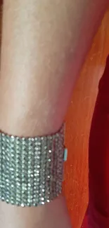 Arm in red dress with sparkling bracelet.