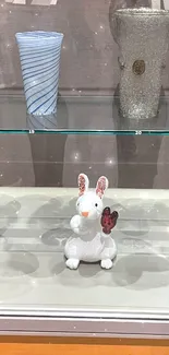 Intricate glass art display featuring a rabbit sculpture.