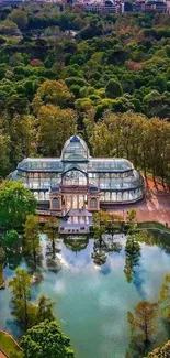 Aerial view of a glass palace in a green park with a reflecting pond.