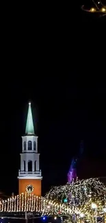 City nightscape with lights and spire against black sky.