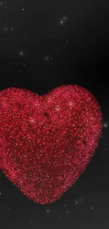 Red glitter heart on black background with sparkling effect.