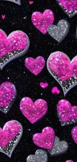 Glittering pink and silver hearts on black background.