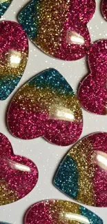 Vibrant glitter hearts with pink, gold, and teal colors on wallpaper.