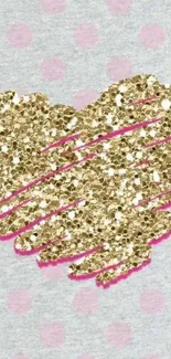 Gold glitter heart on pastel pink polka dot background.