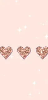 Three glittery hearts on a pastel pink background.