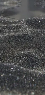 Shimmering black sand texture wallpaper for mobile.