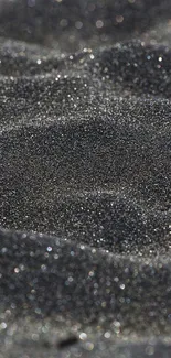 Glittering black sand close-up texture.